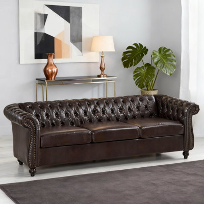 Canapé classique Chesterfield 3 places avec capitonnage à boutons, accoudoirs à volutes et garniture cloutée élégante pour un style de salon intemporel.