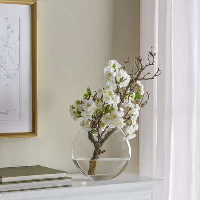 Branche de cerisier en fleurs dans un vase en verre blanc