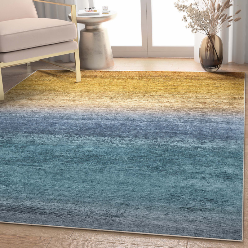 Area rug in a blue and gold gradient ombre design with a textured flat-weave surface.