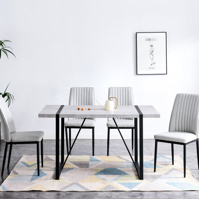 Salle à manger rectangulaire grise avec 5 chaises en similicuir et une table de protection pour la maison