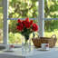 Fleurs artificielles en soie rose dans un vase en verre transparent avec de l'eau artificielle-1247399435