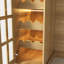 Îlot de cuisine de 200 cm de large avec 6 tiroirs, armoires vitrées, rangement pour bouteilles et éclairage, couleur naturelle