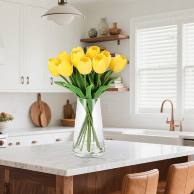 Vraies tulipes artificielles dans un vase en verre avec de l'eau artificielle, décor de table jaune