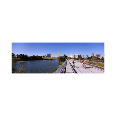 Bicyclists Along the Sacramento River with Tower Bridge in Background, Sacramento, Sacramento County, California, USA 1 Piece Wrapped Canvas Panoramic Wall Art