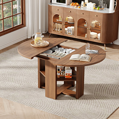 Table de salle à manger extensible ronde à ovale de 109 à 150 cm de large pour 4 à 6 personnes, avec rangement dissimulé et piètement en croix, style ferme moderne.