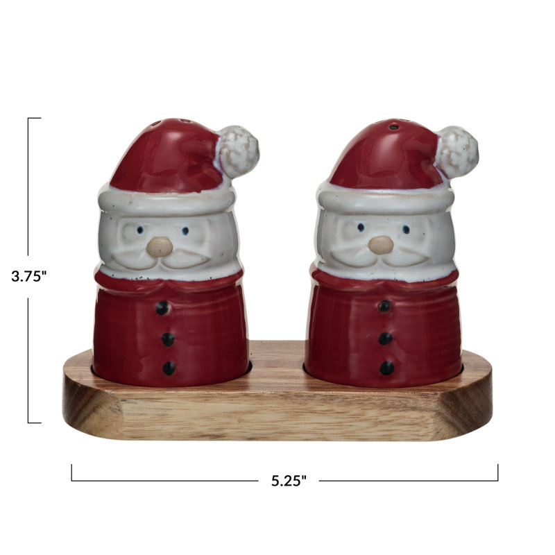 Salière et poivrière en grès en forme de père Noël sur un plateau en bois d'acacia