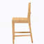 Tabouret de comptoir moderne de style bohémien avec rotin tissé et conception ajourée, parfait pour des sièges élégants et confortables.