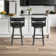 Deherrera Modern Swivel Counter or Bar Stool with Open Low Back and Footrest in Metal and Faux Leather