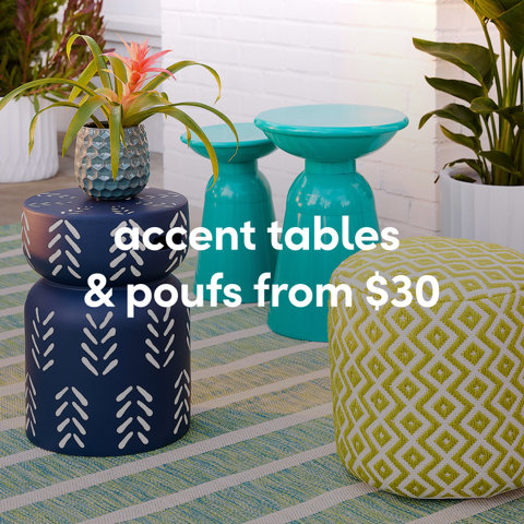 Outdoor lifestyle shot of navy and teal patterned metal accent tables and a green geometric pouf from $30.