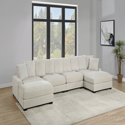 Fauteuil en velours côtelé beige avec coussins et pieds en bois