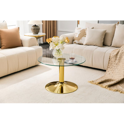 Table basse ronde en verre trempé de 27,5 pouces de diamètre. 17,7 pouces de haut, soutenu par une base en métal doré, avec un bord de luxe léger.