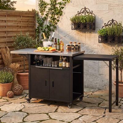 Cuisine d'extérieur avec deux plateaux de table en acier inoxydable, un support à déchets et une armoire de rangement à deux portes