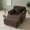 Fauteuil club velouté avec accoudoirs roulés, garniture cloutée et coussin décoratif