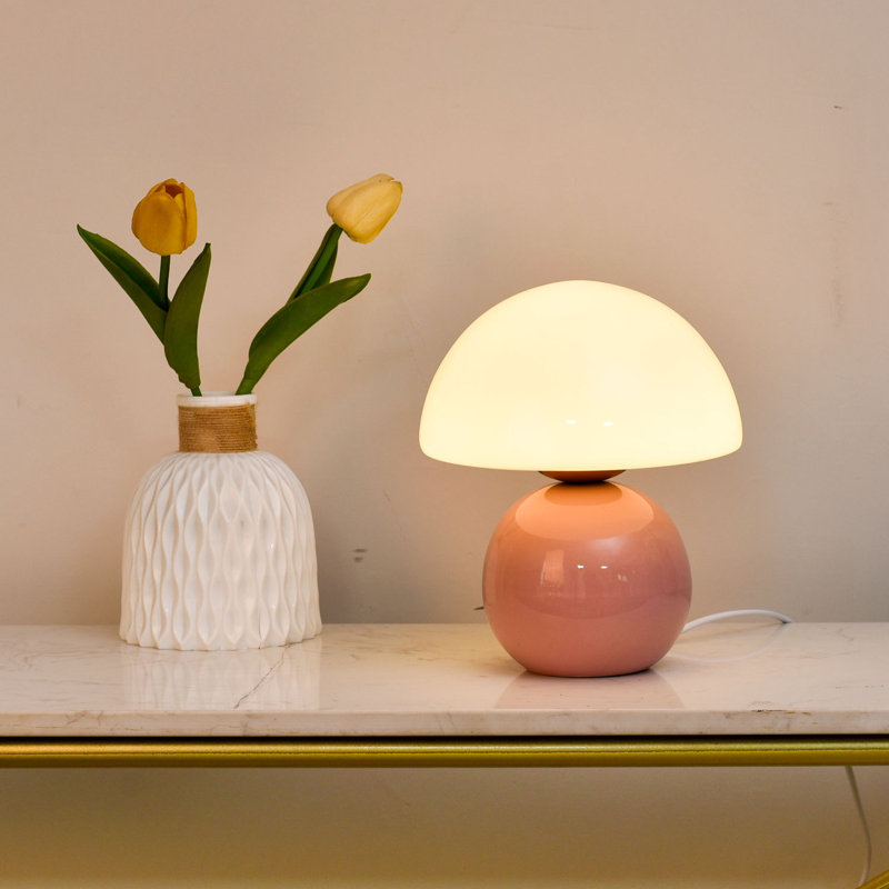 Cette lampe de table champignon enchanteresse allie fonctionnalité et design fantaisiste. La douce finition crème rose et la forme de champignon organique créent une charmante esthétique rétro qui s'harmonise avec les décors modernes, scandinaves ou