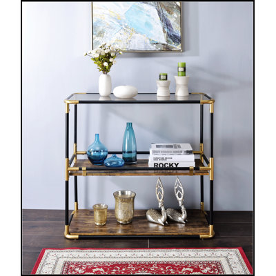 Le plateau en verre fumé Heleris et la console à finition noire et dorée sont parfaits pour les décors modernes et luxueux.