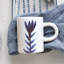 Tasse en grès peinte à la main avec motif floral dans un glacis réactif