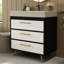 Meuble-lavabo sur pied contemporain avec lavabo en céramique intégré et surface en pierre frittée. Ce meuble-lavabo offre un support stable avec ses pieds en acier thermolaqué et ses poignées encastrées dorées. L'évier a un grand