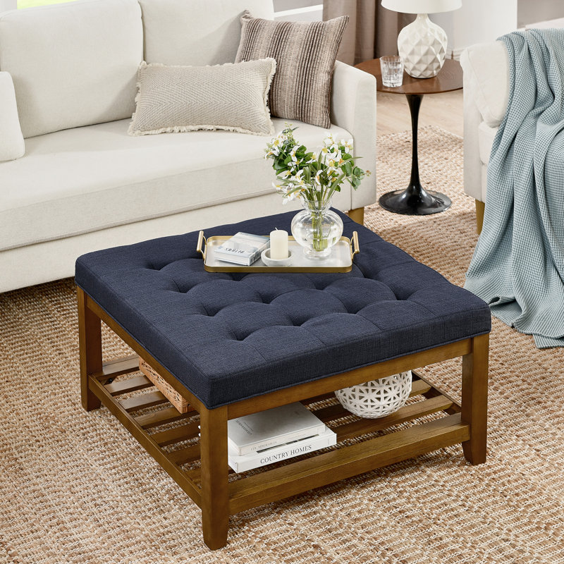 Table basse avec tablette en bois de hêtre, lin bleu marine, repose-pieds spacieux pour le cadre du salon revêtu de capitonnage et d'espace