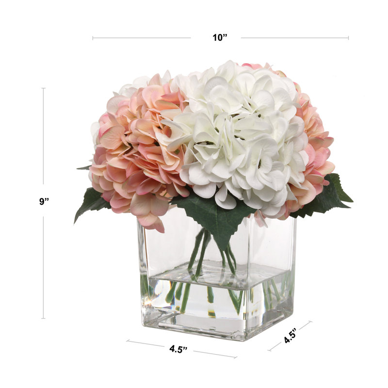 Hortensias roses et blanches dans un vase en verre avec de l'eau