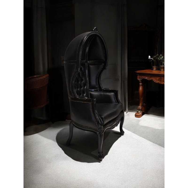 Fauteuil capitonné en similicuir noir capitonné