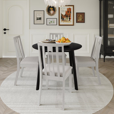 Ensemble de salle à manger 5 pièces avec table ronde noire et chaises à dossier vertical rembourrées blanches