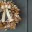 Couronne de Noël ornée de pommes de pin et d'ornements pré-éclairés avec minuteur en or 26 po