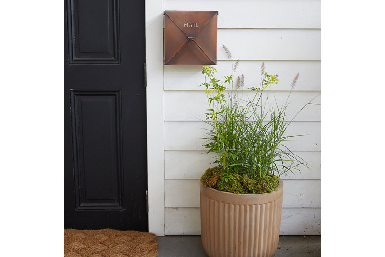 bronze wall mount mailbox beside black door