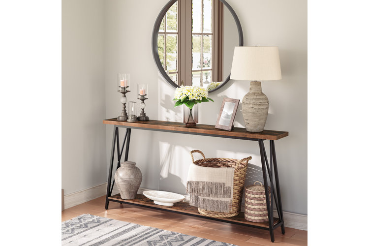 a wood console table with a lamp and basket