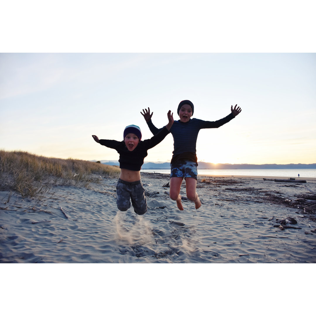 Jungen springen am Strand