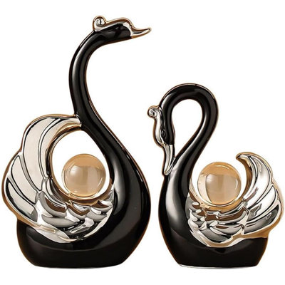 Une paire de figurines de cygnes et de cygnes avec boule de cristal