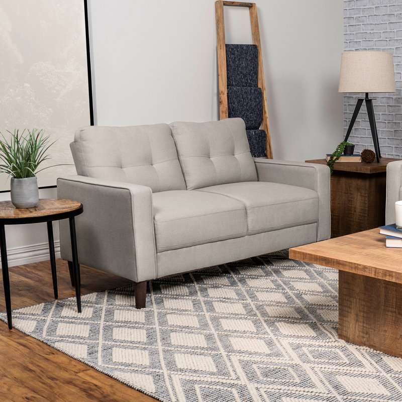 Petit beige tapissier avec détails auto-tissés, dossier quadrillé et accoudoirs, pour les espaces de vie principaux