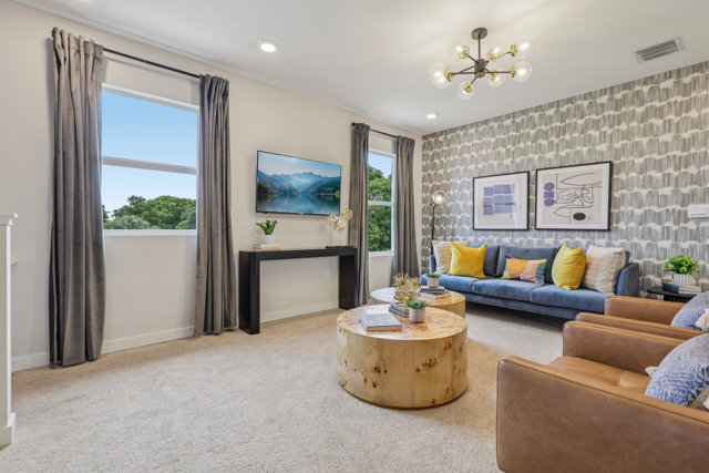 Living room with blue couch and tan armchairs.