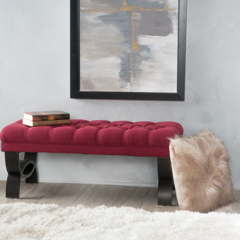 Tissu rouge chic avec surpiqûres en losanges et pieds élégants en demi-cercle capitonnés