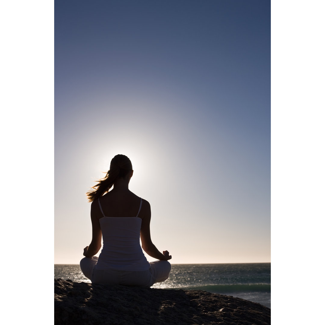 Junge Frau in Lotus-Position sitzend von Neustockimages - Kunstdrucke ohne Rahmen auf Leinwand