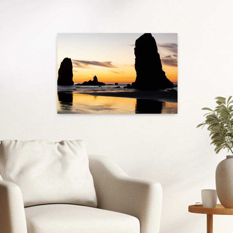 Silhouettes Of Rock Formations At Sunset At Cannon Beach Oregon USA by Dan Merkel - Wrapped Canvas Print