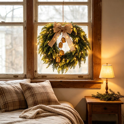 Couronne de Noël artificielle pré-illuminée de 50 cm avec nœud en toile de jute et clochettes dorées vintage, fonctionnant sur piles (non incluses). Parfait pour décorer une porte d'entrée, un mur ou un foyer pendant les fêtes.