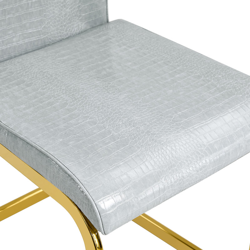 Élégantes chaises d'appoint en métal doré, similicuir gris, polyvalence pour les repas