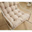 Chaise berçante d'extérieur moderne, structure en acier, coussin beige confortable pour le salon