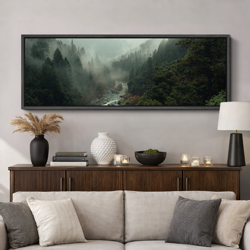 Panoramic landscape canvas wall art in a black floater frame depicting a misty forest river scene.
