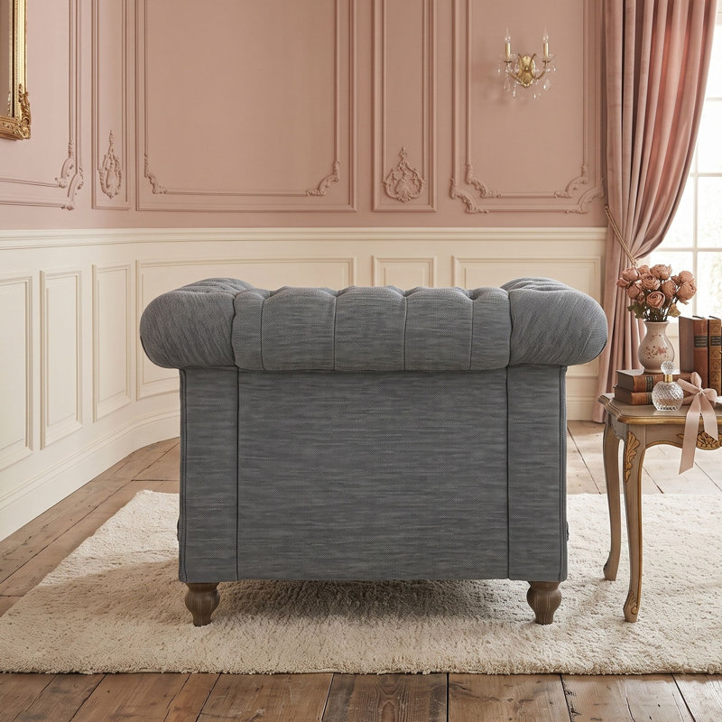 Fauteuil club capitonné avec garniture cloutée