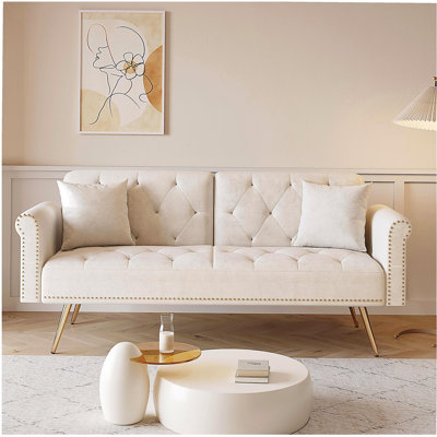 Luxueux canapé-lit en velours beige avec garniture cloutée et coussin décoratif assorti pour une vie élégante