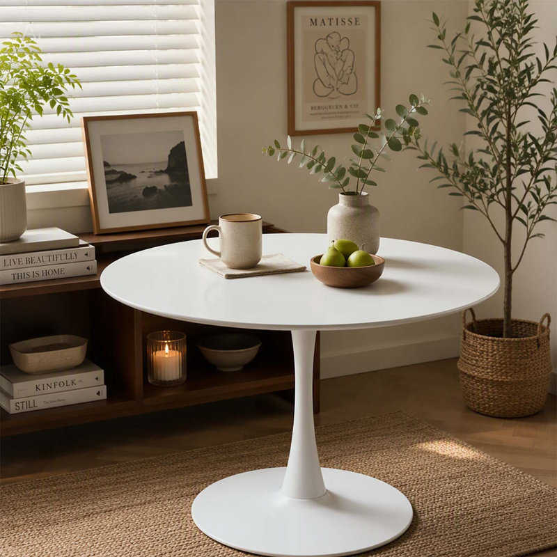 Table de salle à manger ronde blanche moderne avec un piètement robuste à une seule colonne, idéale pour les petits espaces de vie et les cuisines.