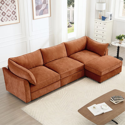 Chenille orange 3 places en forme de L avec croissant, coussins enveloppants, amovibles et sous le rangement, ajoute du charme aux espaces de vie contemporains