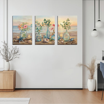 Ensemble de 3 tableaux sur toile représentant des arrangements floraux en bord de mer, parfaits pour décorer un salon, une chambre ou une maison de plage.