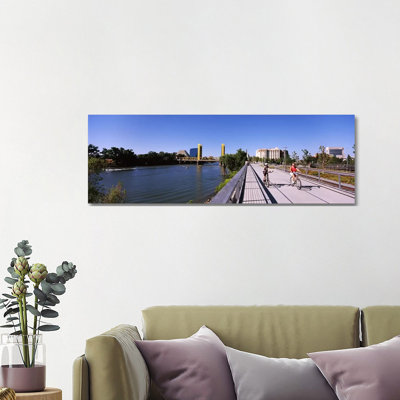 Bicyclists Along the Sacramento River with Tower Bridge in Background, Sacramento, Sacramento County, California, USA 1 Piece Wrapped Canvas Panoramic Wall Art