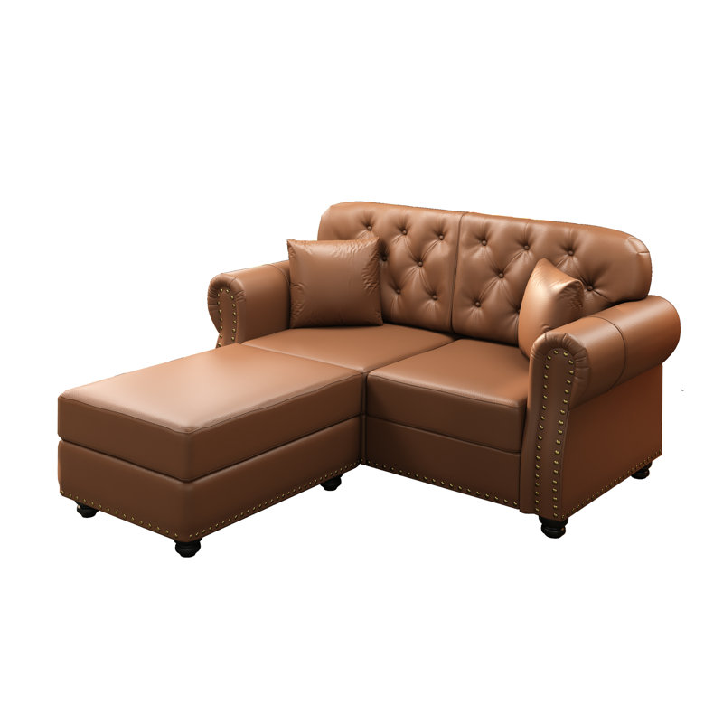 Canapé Chesterfield en similicuir de 63 pouces avec capitonnage à boutons, garniture cloutée, accoudoirs roulés et deux coussins décoratifs pour un confort intemporel et une élégance moderne.