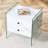 Double-drawer bedside table. The board surface is MDF with white grain sticker, and both sides are transparent tempered glass. The design is simple and elegant, with excellent storage functions.