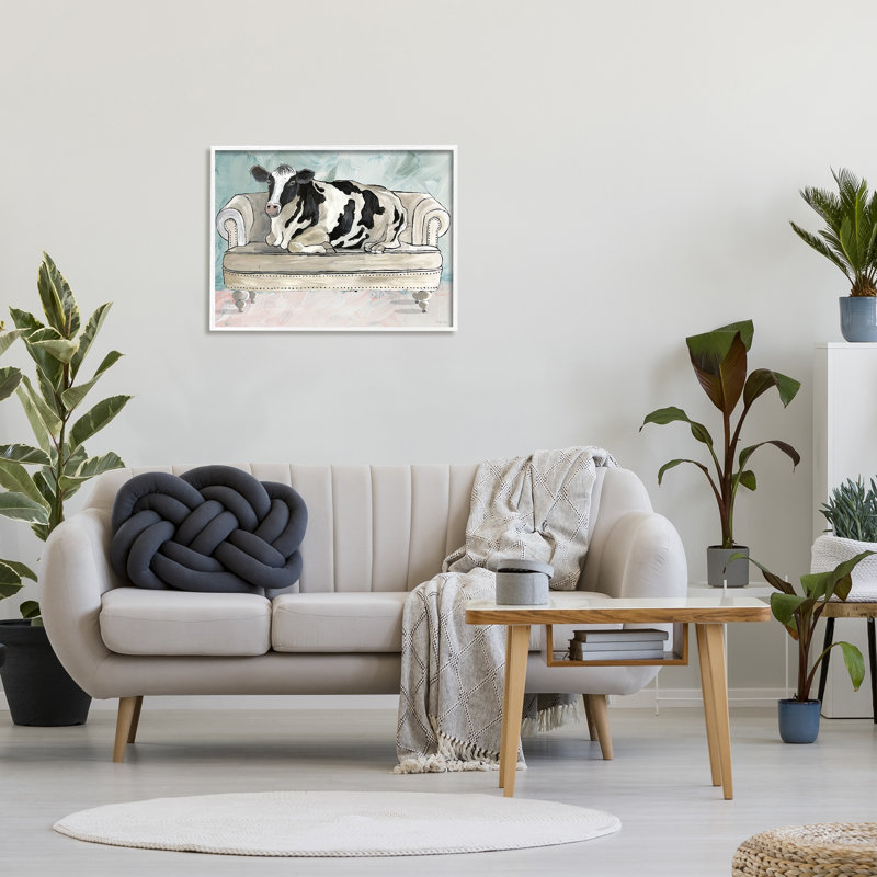 Vache de ferme laitière reposant un canapé glam vert surdimensionné, encadré par une giclée sur fond blanc, par Cindy Jacobs