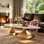 Table basse moderne ovale avec plateau en faux marbre et base sculpturale dorée