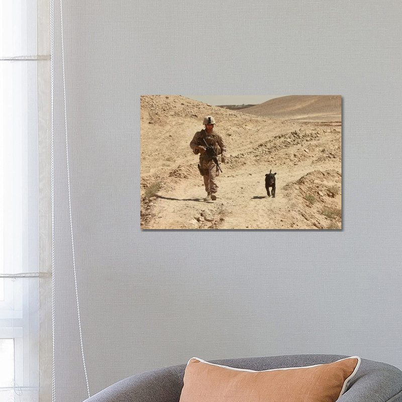 A Dog Handler Walks With An Explosives Detection Dog While On Patrol by Stocktrek Images - Wrapped Canvas Print